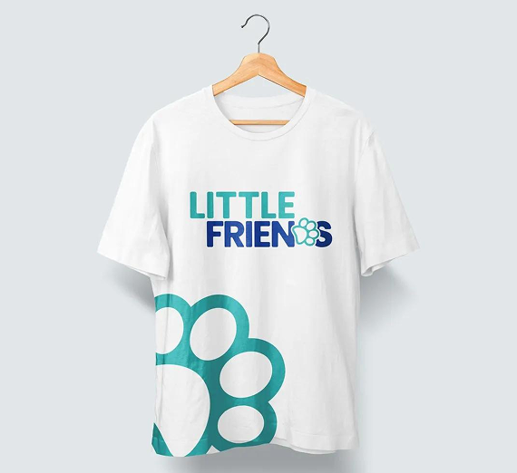 A white t-shirt on a hanger with a teal paw print logo and the text