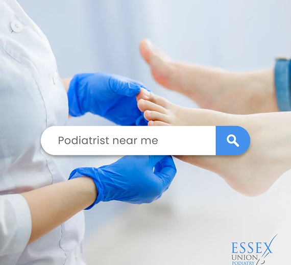 A healthcare professional in blue gloves examines a patient's feet