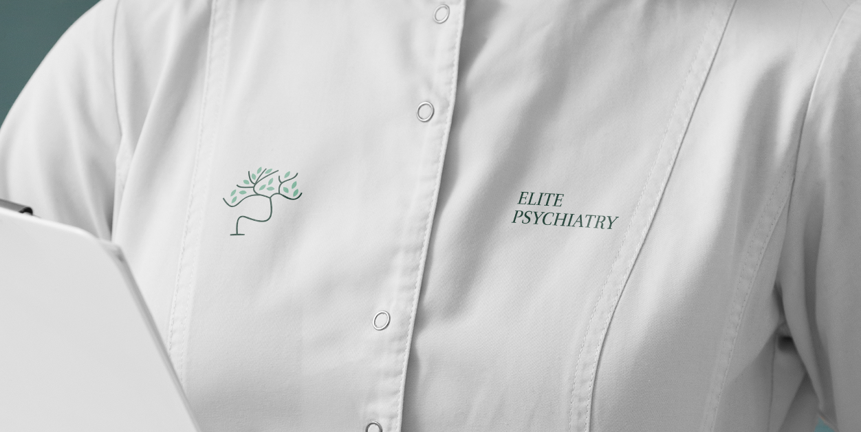 A white medical coat features a green, tree-shaped neural logo and the embroidered text 