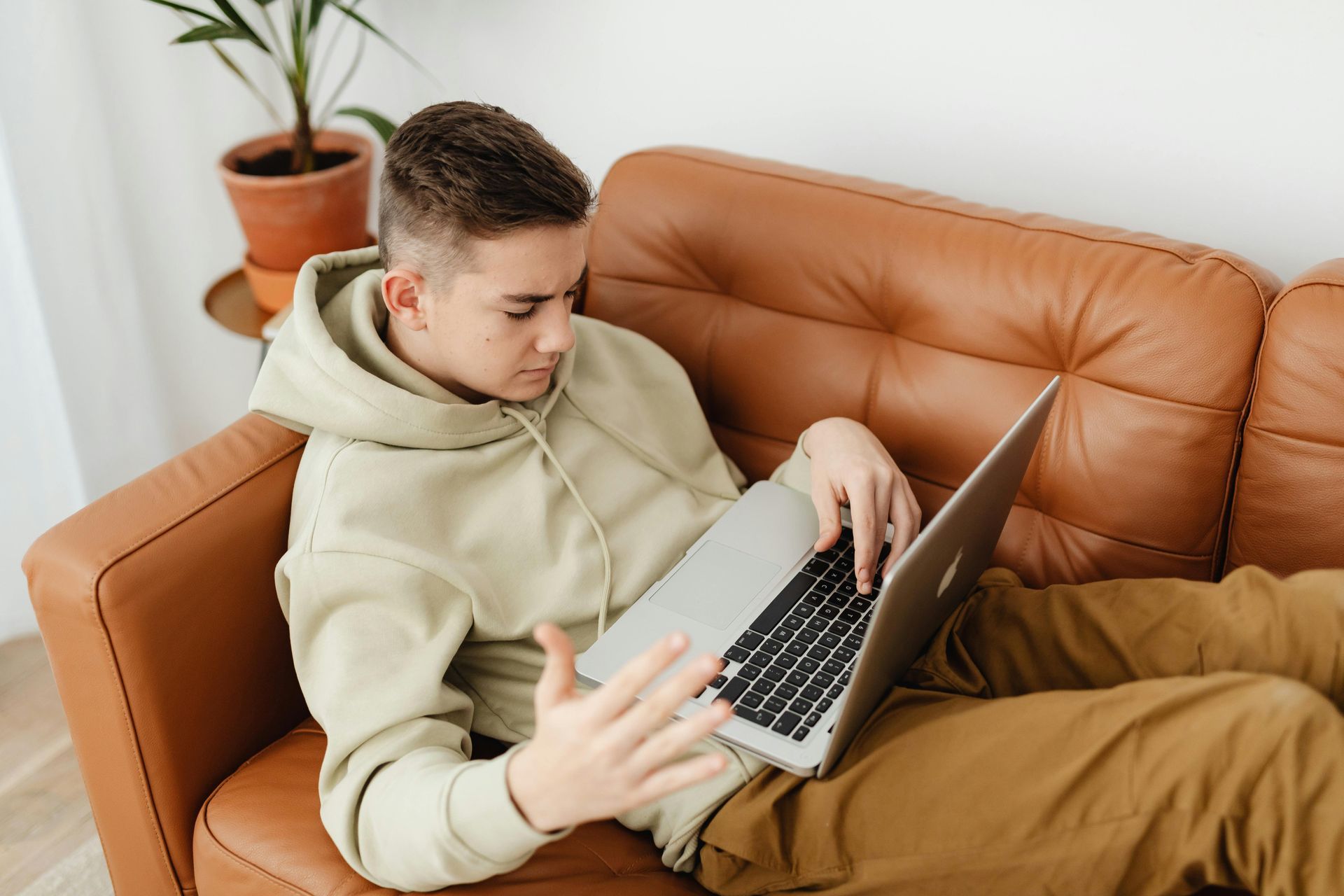 student sitting on a couch working on computer