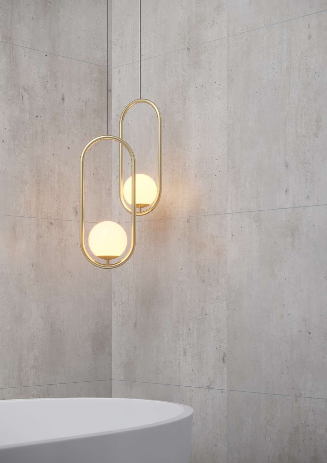 Two gold pendant lights with glowing orbs, hanging against a textured gray wall above a white curved surface.