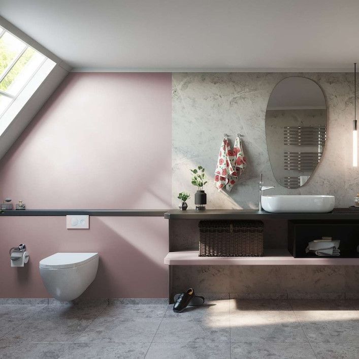 Modern bathroom with pink and gray walls, toilet, sink, mirror, towel, and shelving.