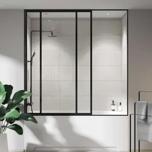 Black-framed glass shower enclosure over a white tub with black shower fixtures, set in a white-tiled alcove.