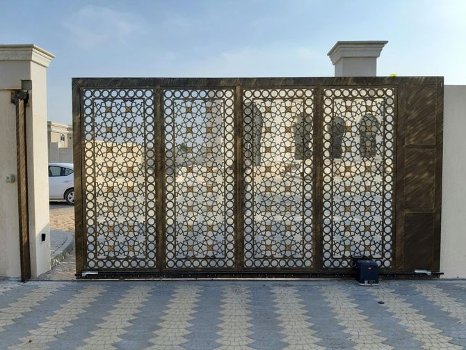 Ornate laser-cut metal sliding gate with geometric patterns.