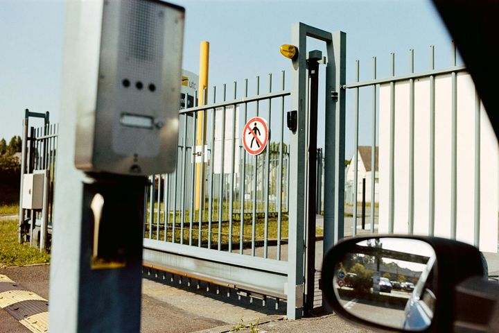 Keypad access control system next to a sliding security gate.
