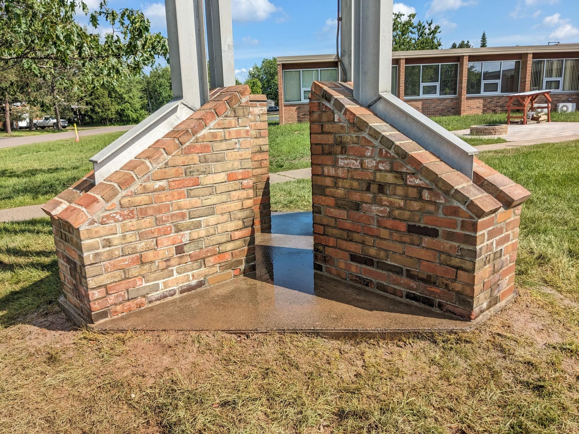 A brick structure is sitting in the middle of a grassy field.