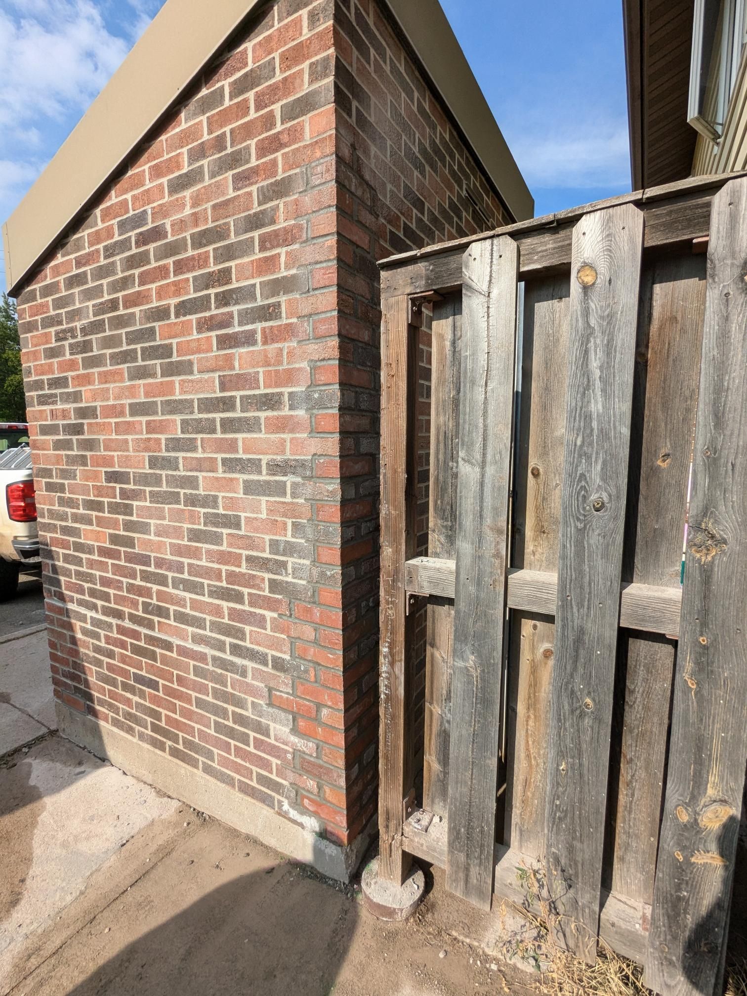 A brick building with a wooden fence in front of it