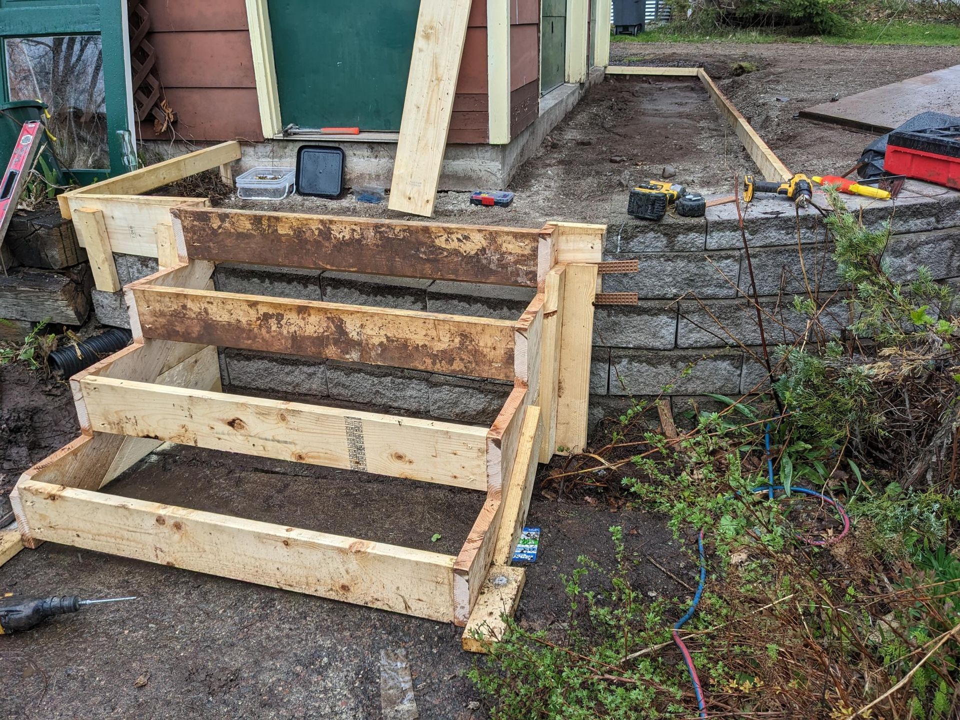 A wooden staircase is being built in front of a house.