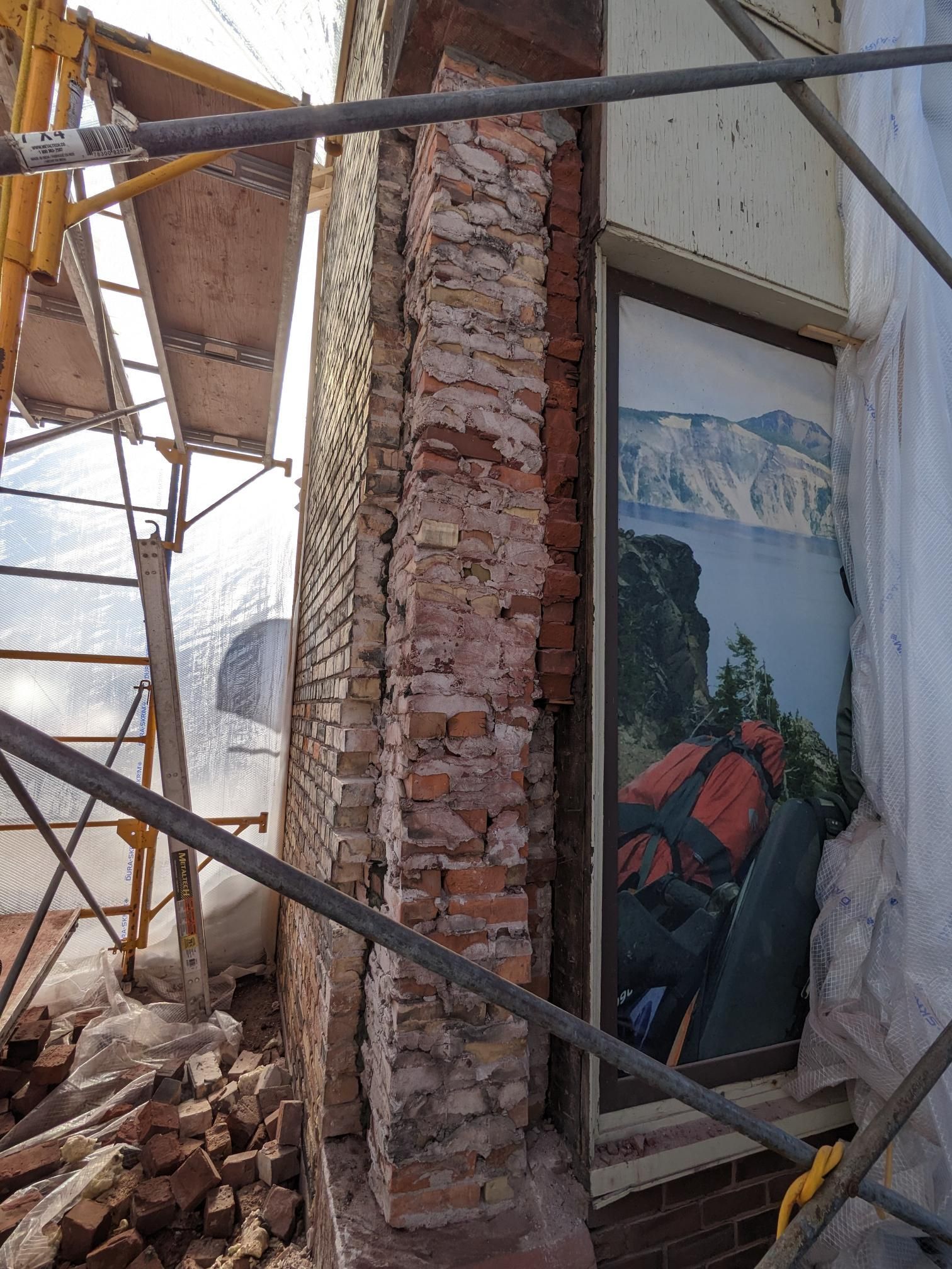 A brick wall with a picture of a backpack on it