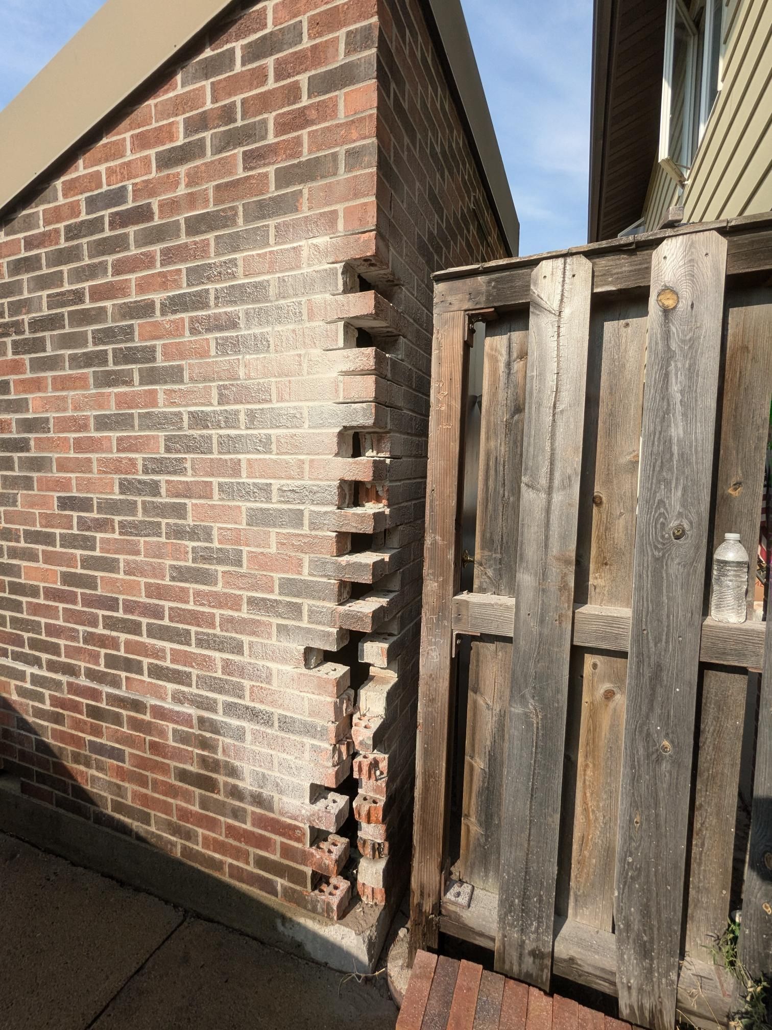 A brick wall with a wooden fence in front of it.