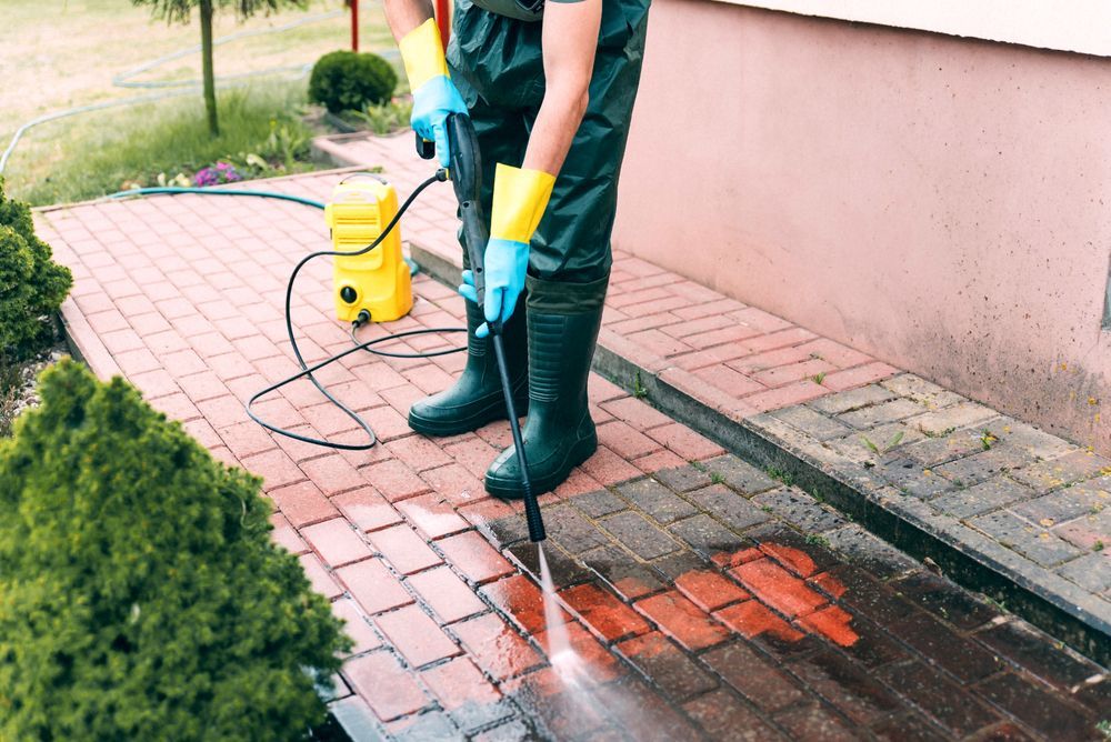 Person Power Washing a Brick Walkway — Coastal Pressure Solutions in Paradise Point, QLD