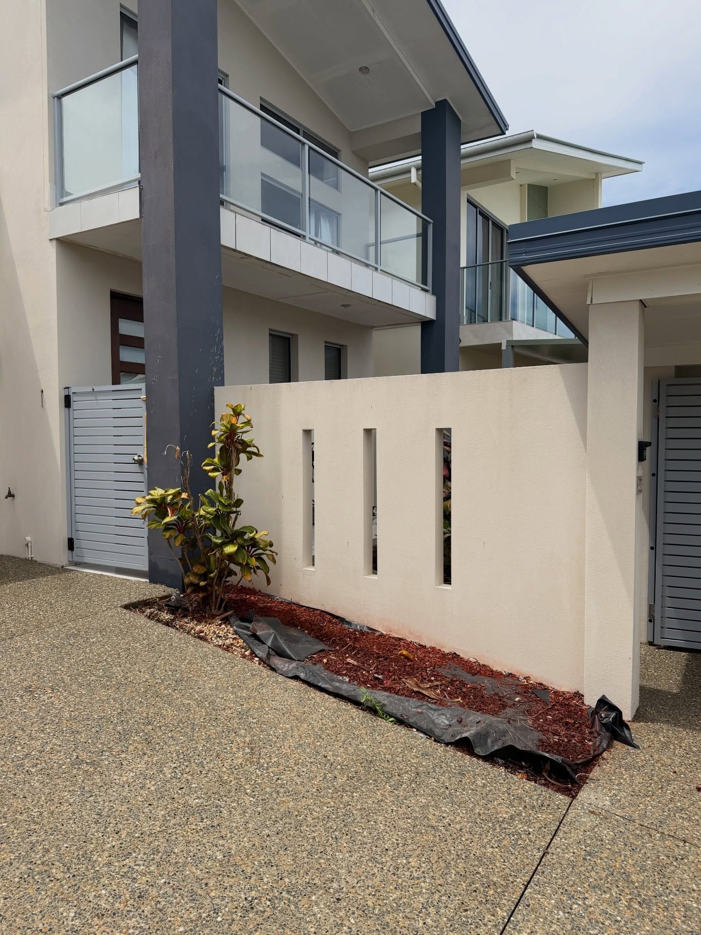 A Modern Two-story Home With a Beige Facade — Coastal Pressure Solutions in Oxenford, QLD