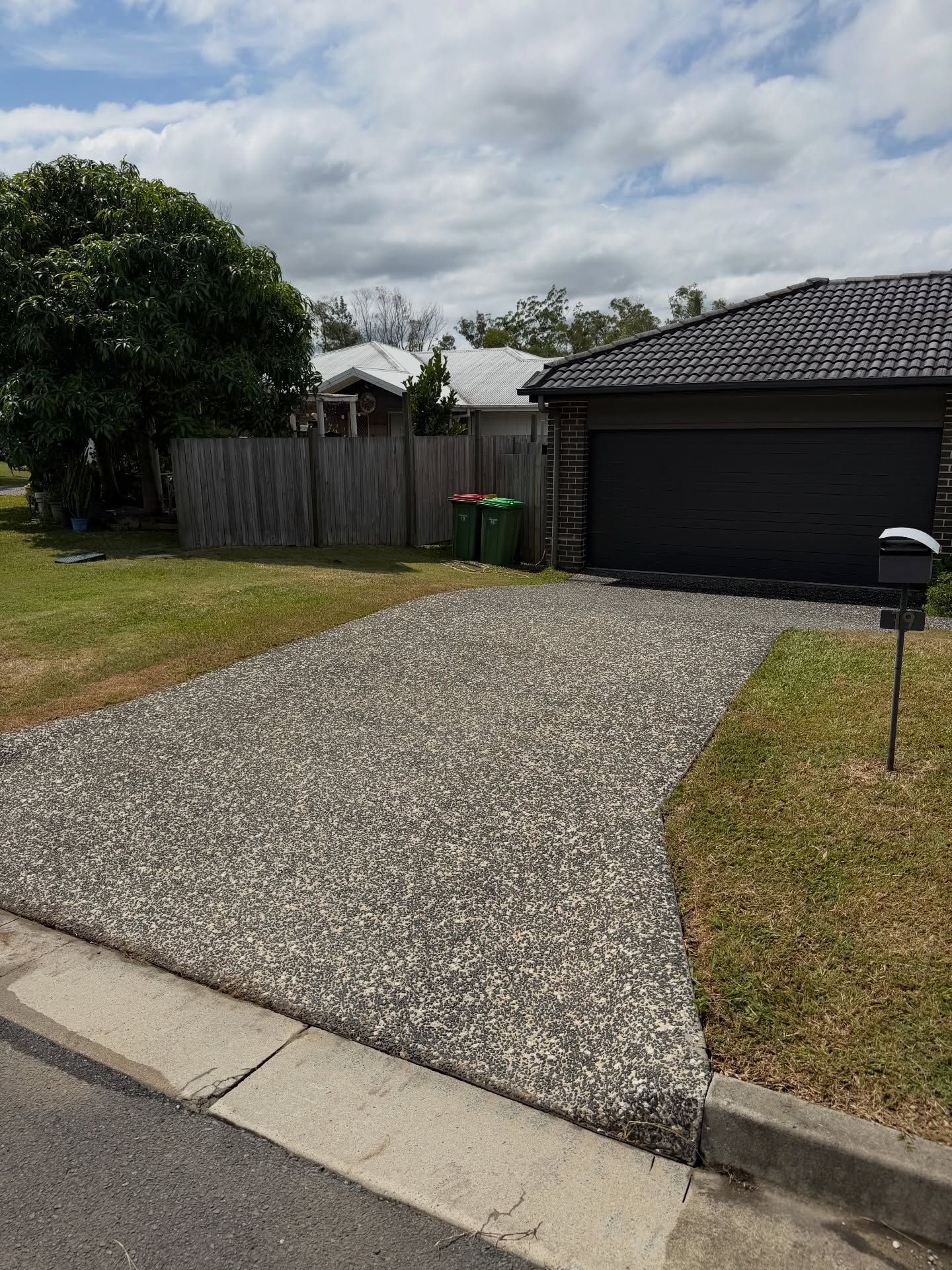 Driveway Made of Small Stones Leading to a Garage — Coastal Pressure Solutions in Runaway Bay, QLD