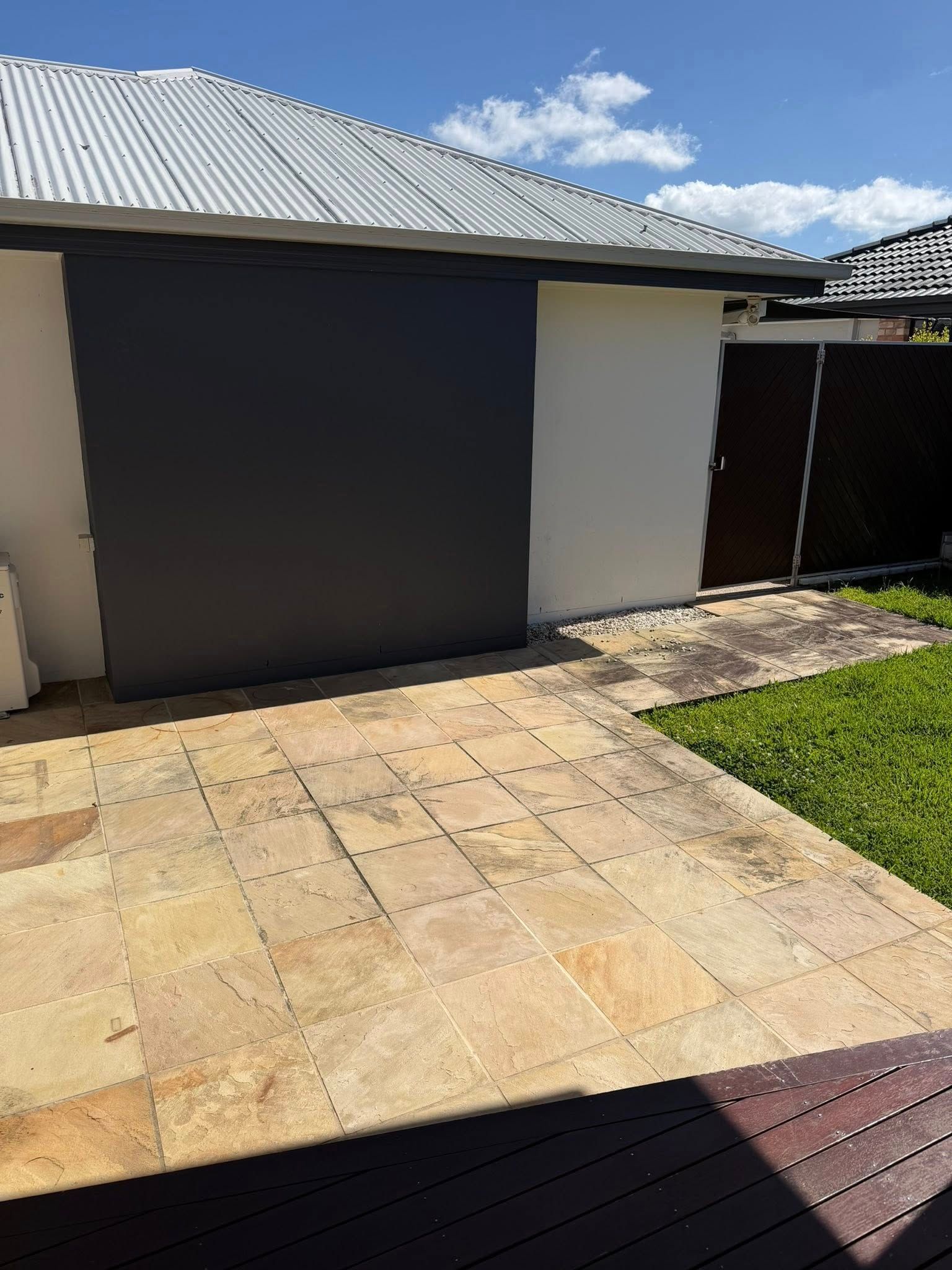 A Paved Patio Next to a Gray and White Building — Coastal Pressure Solutions in Oxenford, QLD