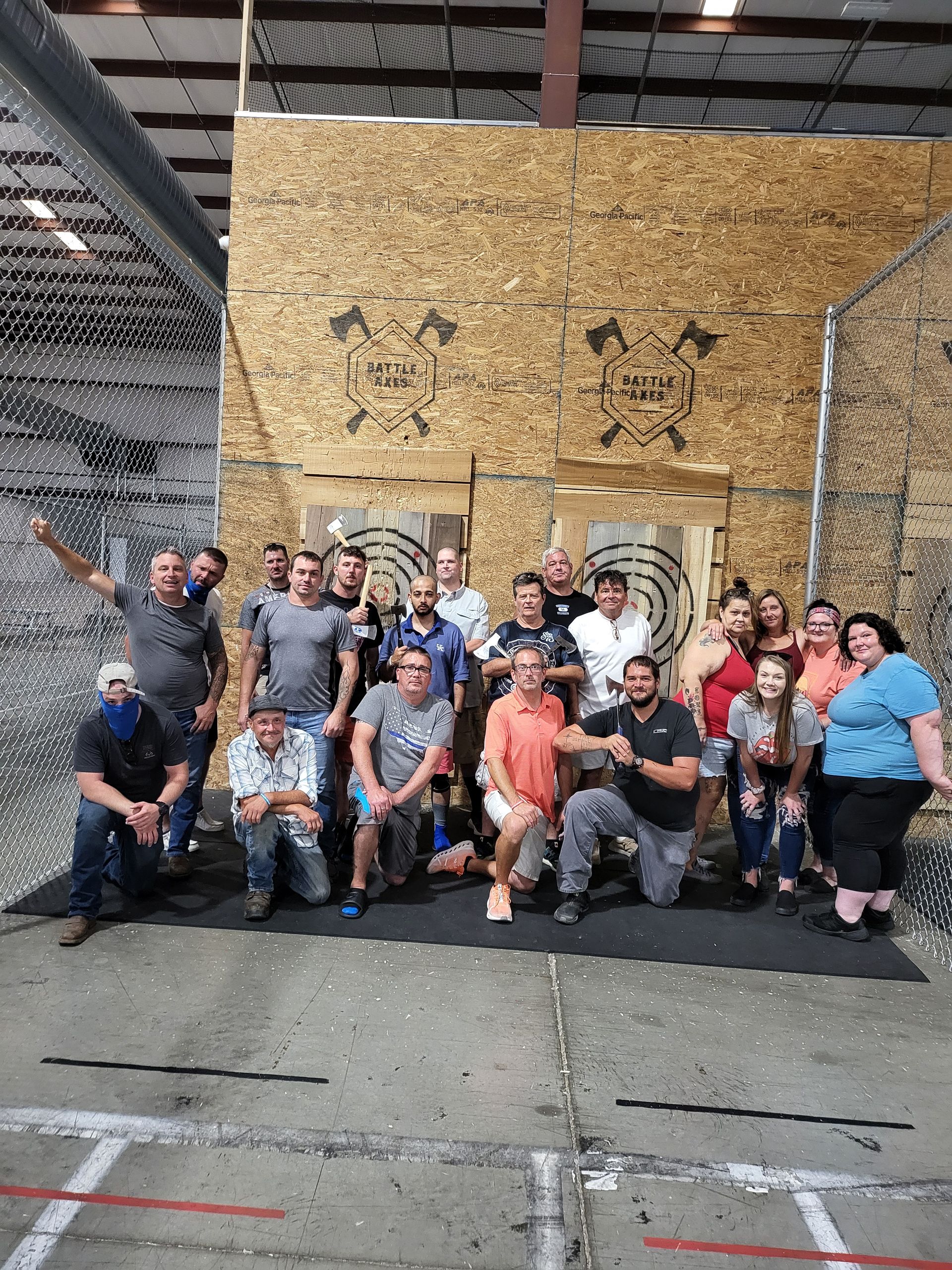A group of people are posing for a picture in front of a wooden wall.
