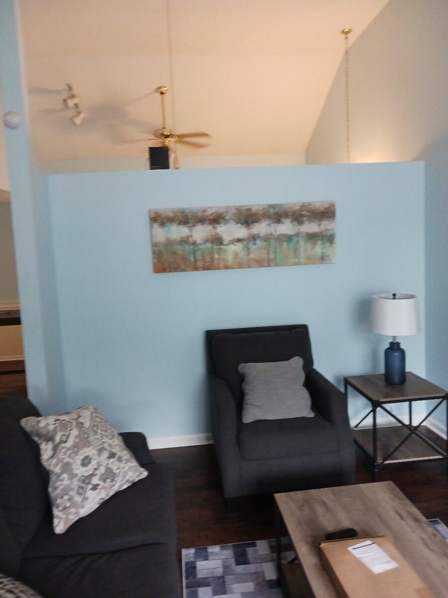 A living room with a couch a chair and a lamp