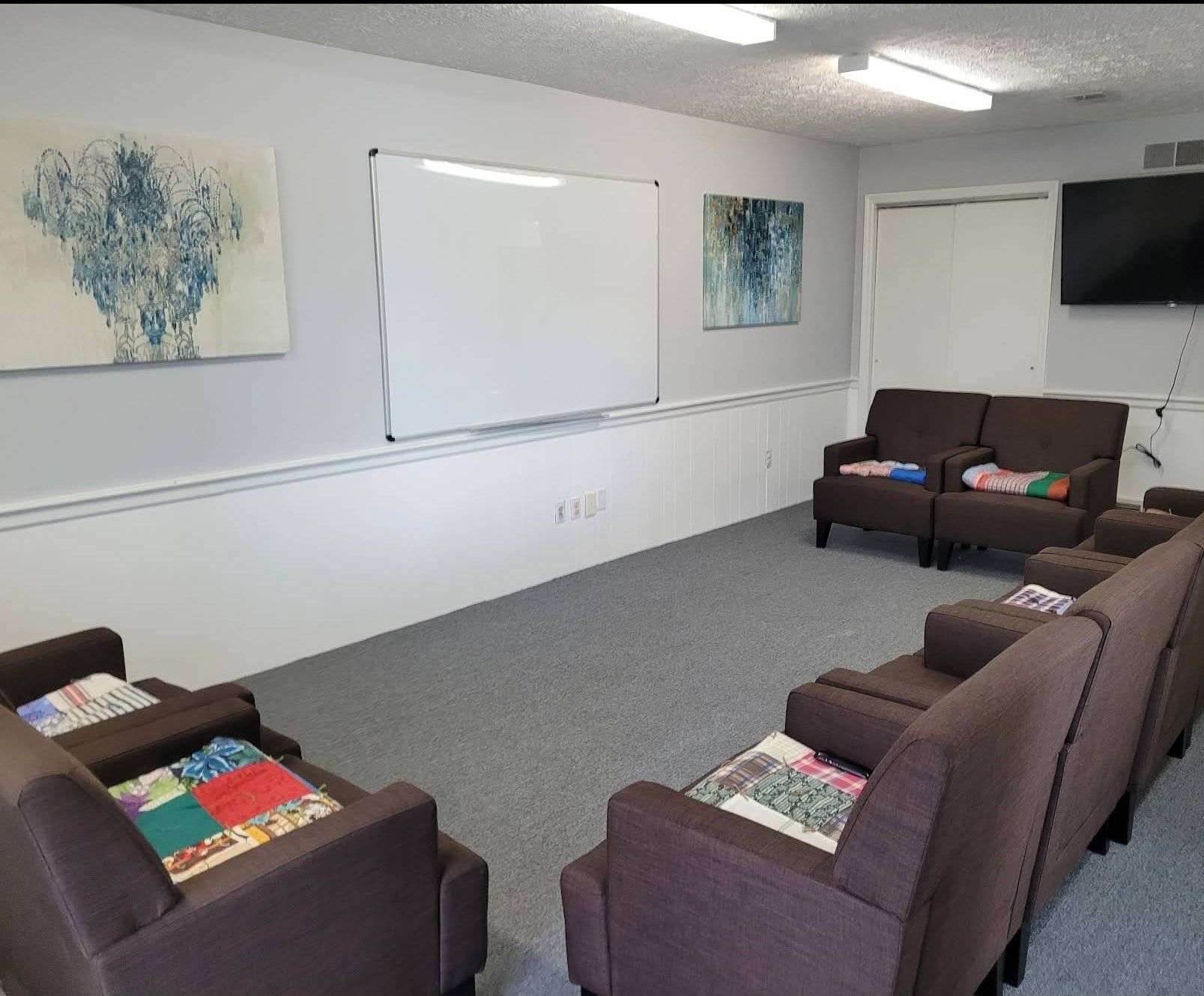 A room with a lot of chairs and a whiteboard