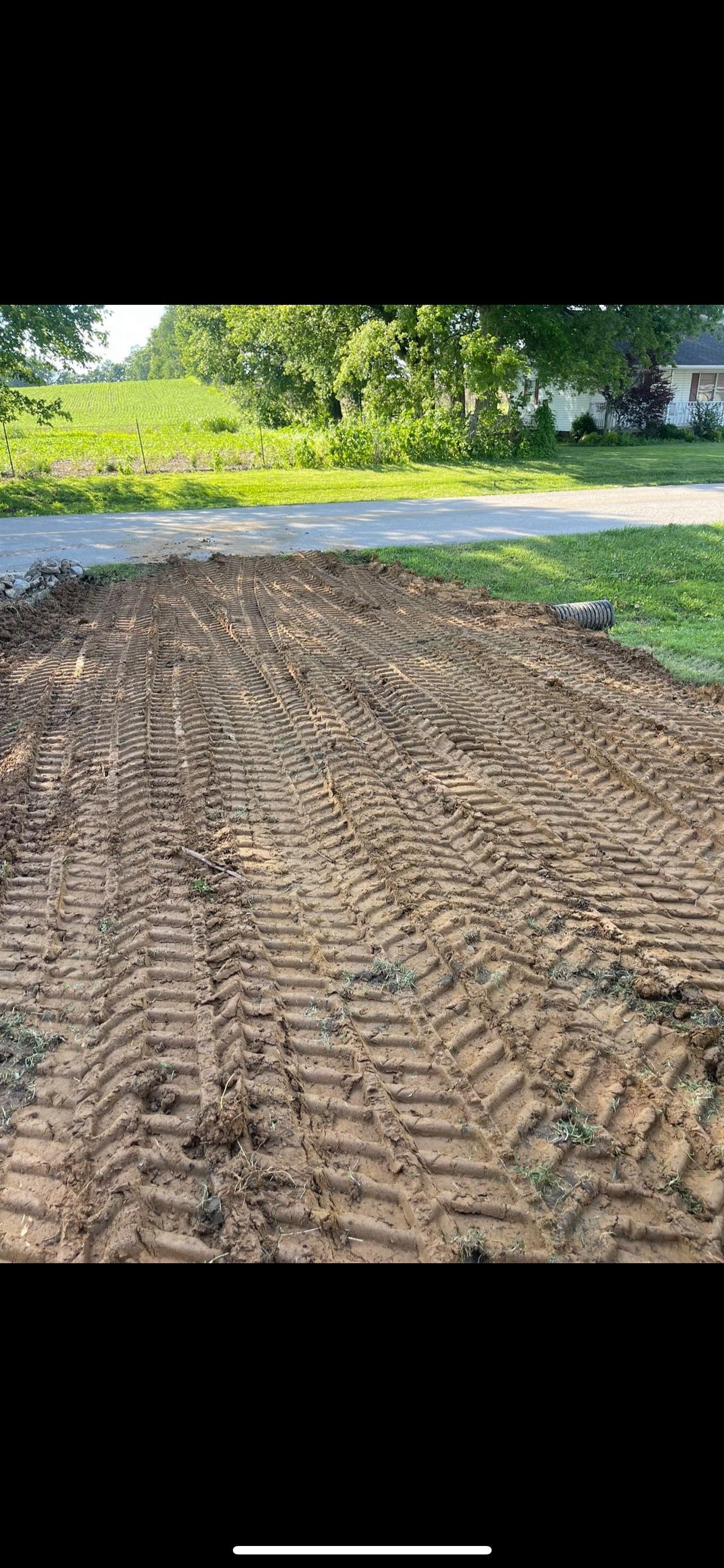 A large pile of dirt is sitting next to a road.