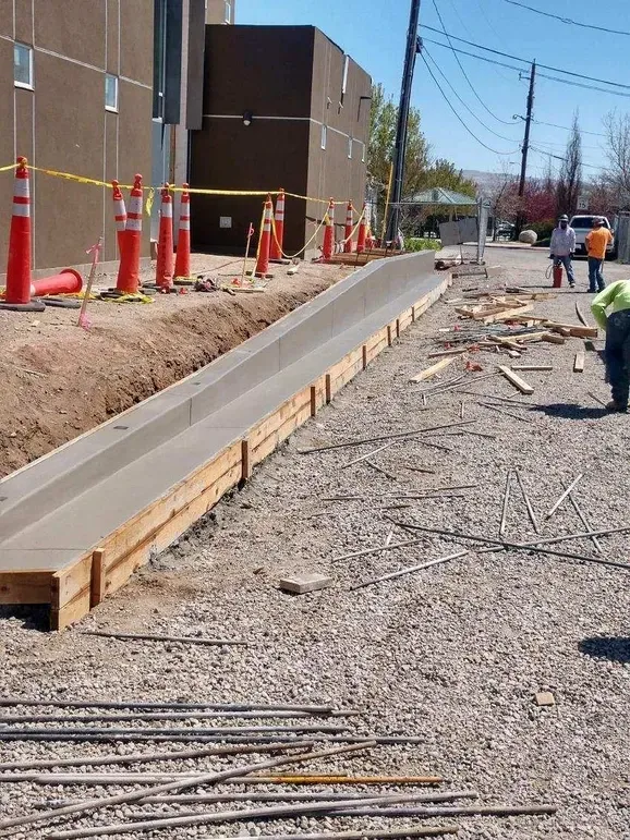 Construction workers are working on a sidewalk in front of a building