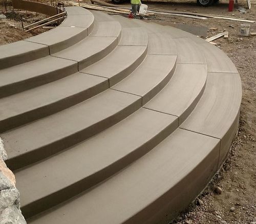 A set of curved concrete steps are being built