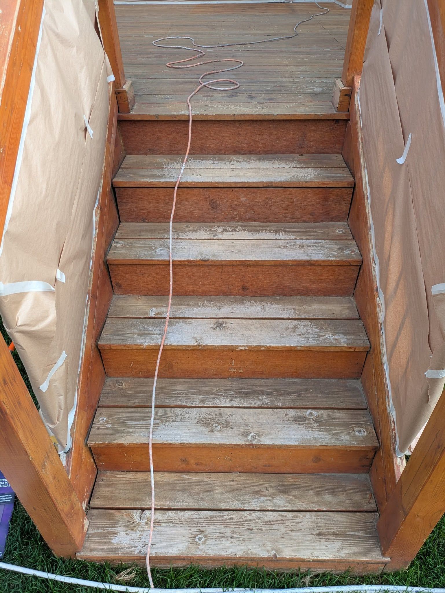 Wooden staircase with worn steps and white paint on the side rails outdoors