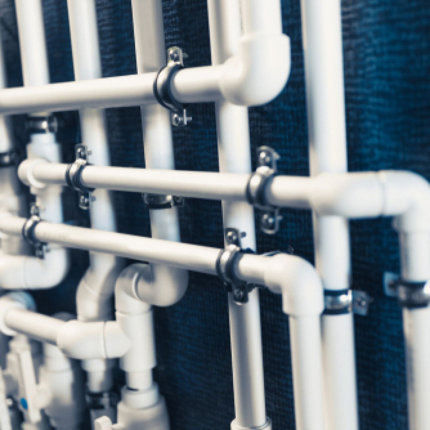 A bunch of white pipes are lined up on a wall