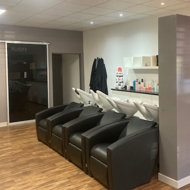 a-row-of-four-black-salon-shampoo-chairs