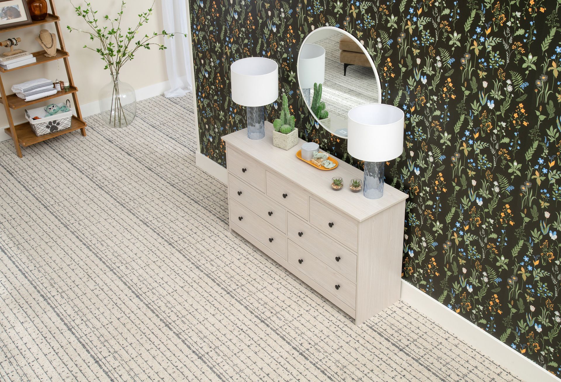 Bright modern bedroom with patterned wallpaper, dresser, mirror, lamps, and white rug