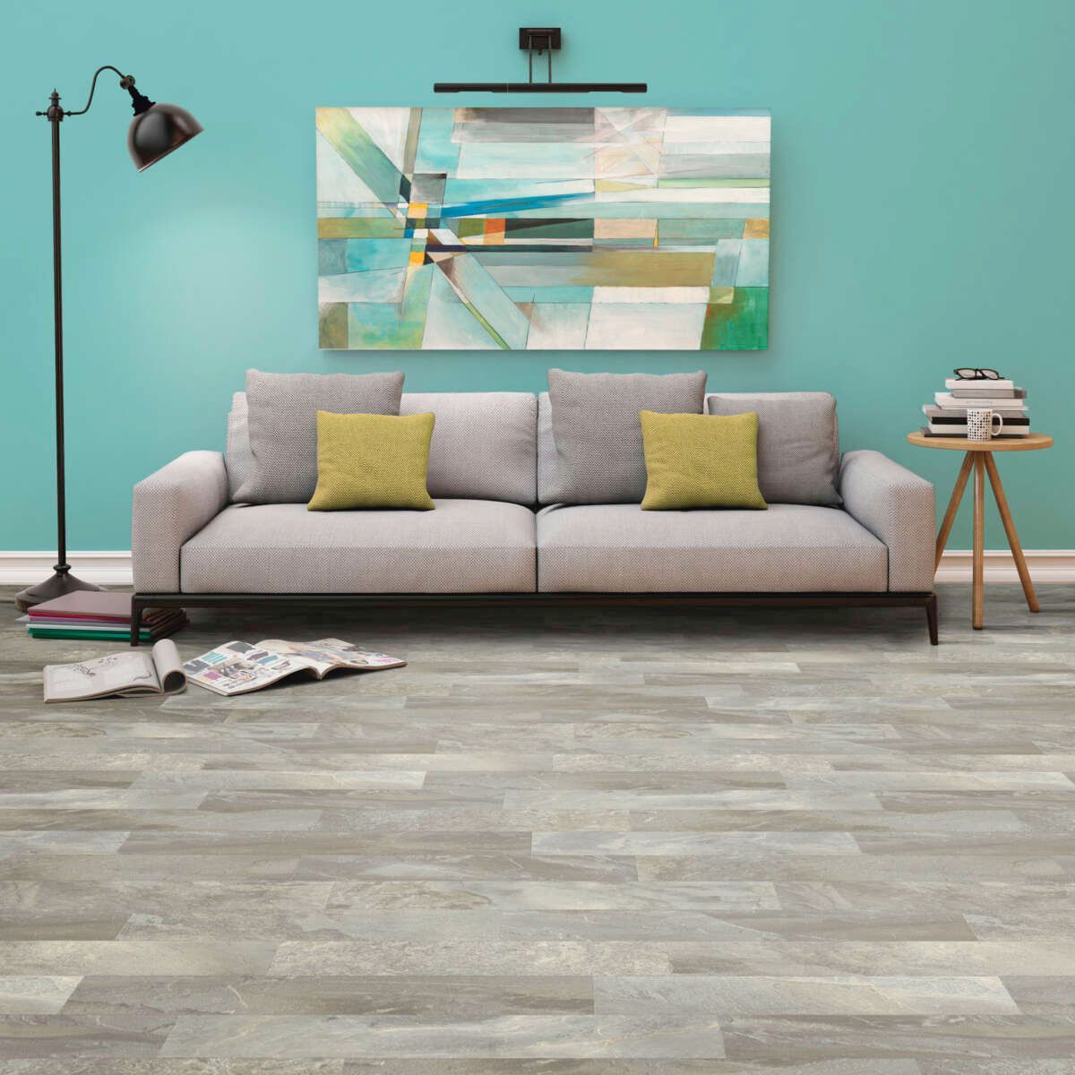 Modern living room with gray sofa, yellow pillows, floor lamp, abstract wall art, and wood flooring.