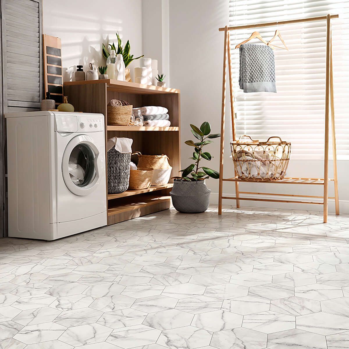 Bright laundry room with a washer, wooden shelves, a clothing rack, and a large patterned rug