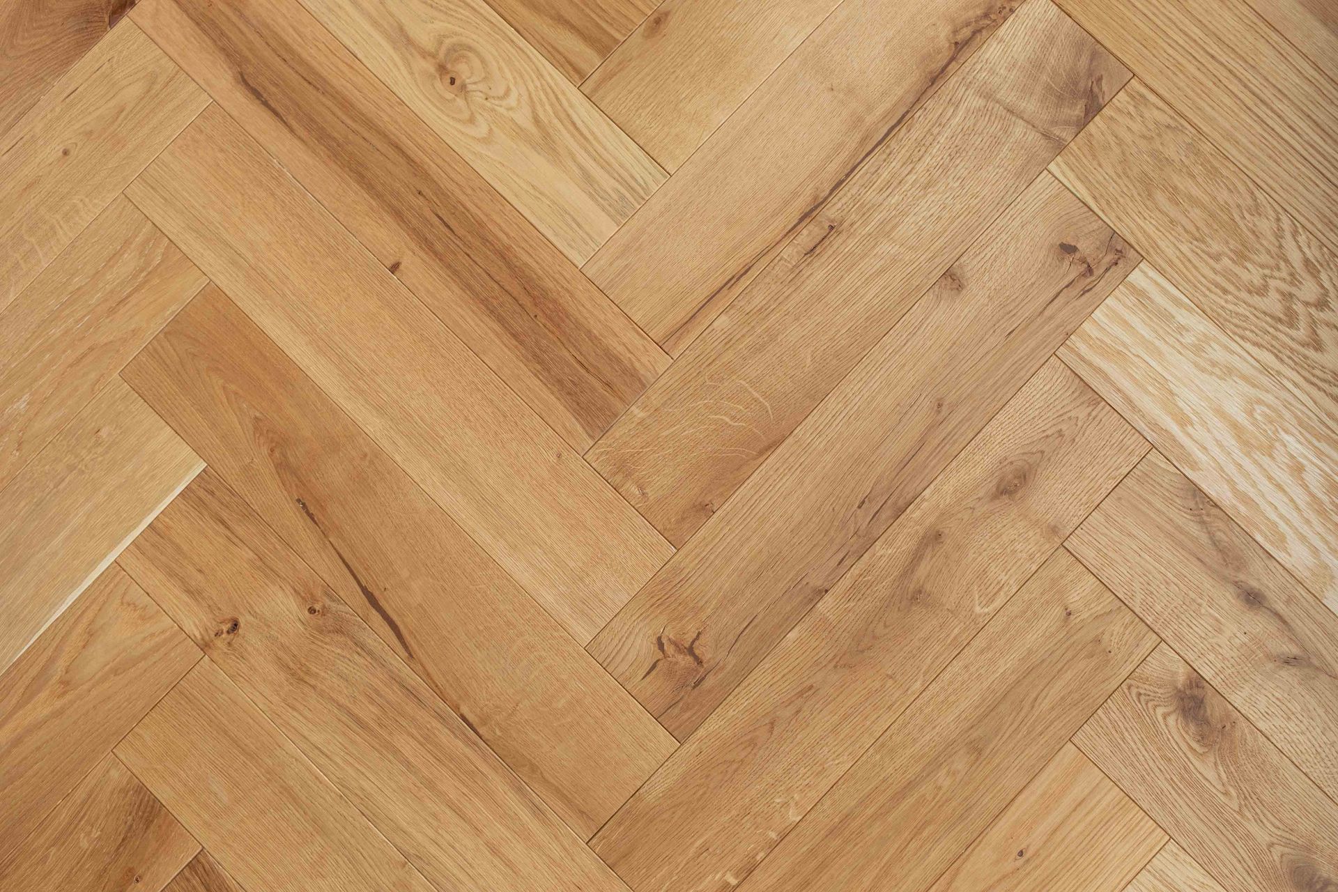 Herringbone pattern wooden floor in shades of light brown. Herringbone pattern wooden floor in shades of light brown.