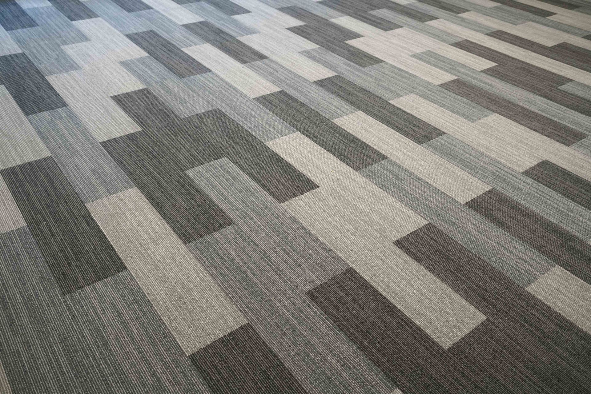 Gray and beige patterned carpet tiles in a room