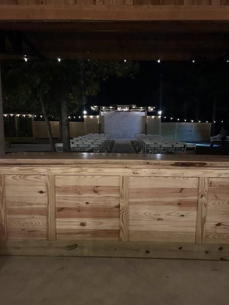 Outdoor stage with rows of chairs and wooden railing at night