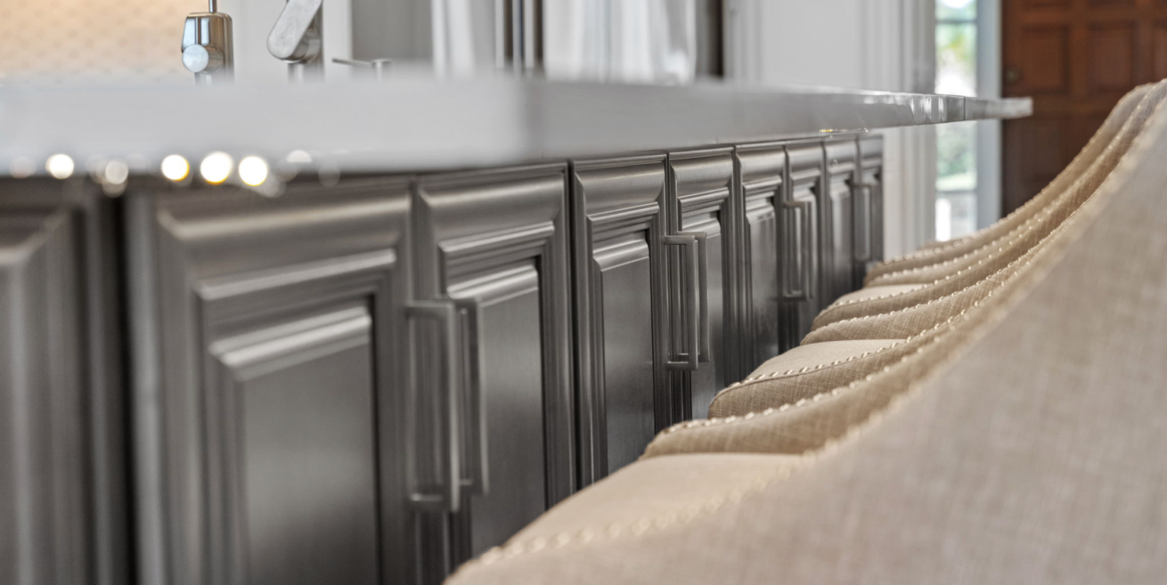 Row of dark gray barstools lined along a kitchen island in a bright modern interior