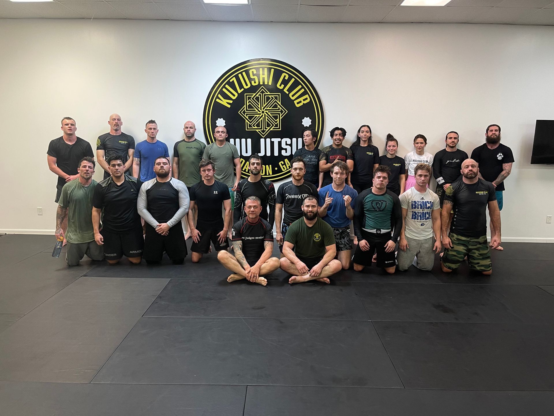 A group of people are posing for a picture in a gym.