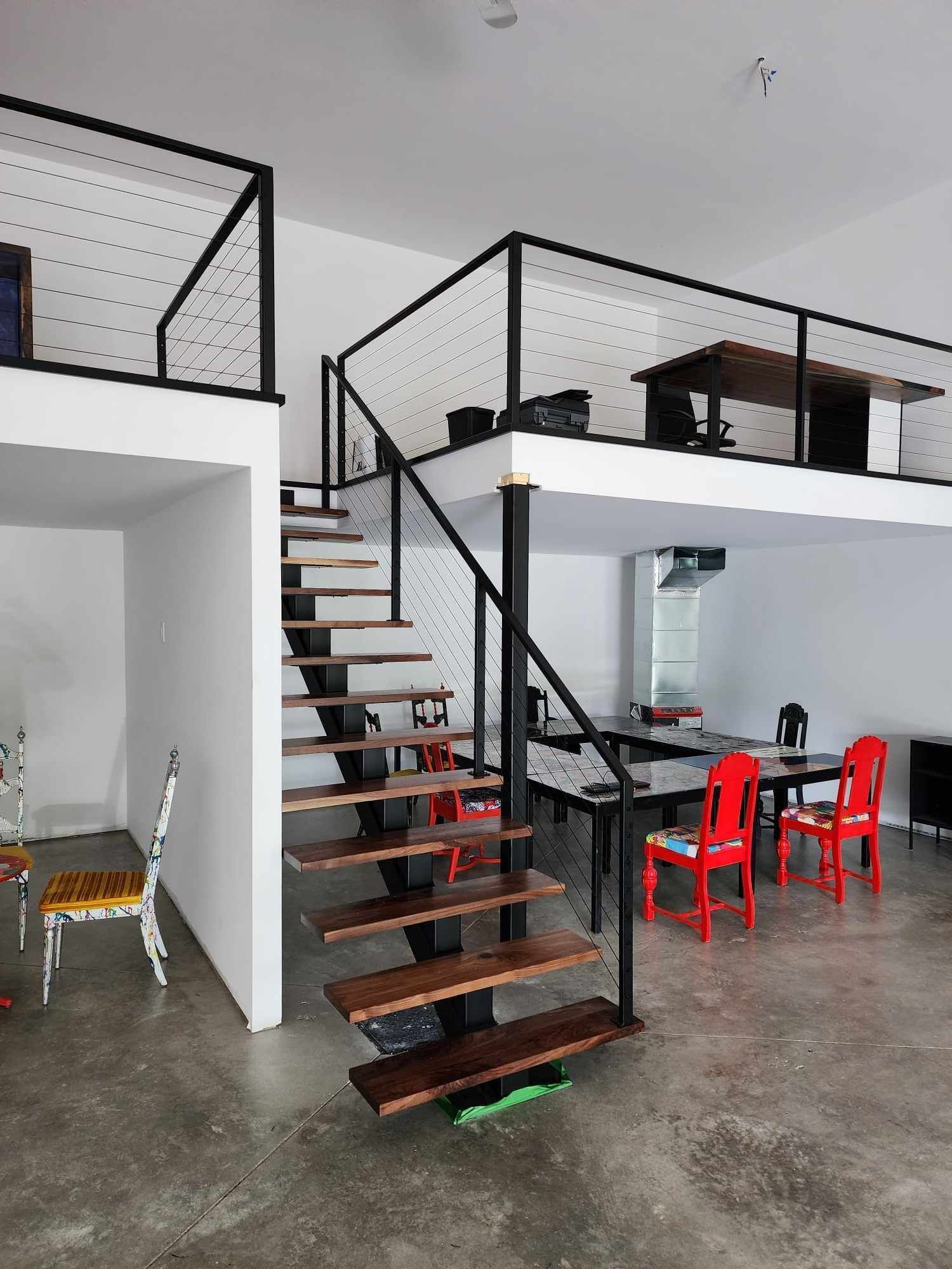 Un escalier menant à un deuxième étage avec des tables et des chaises