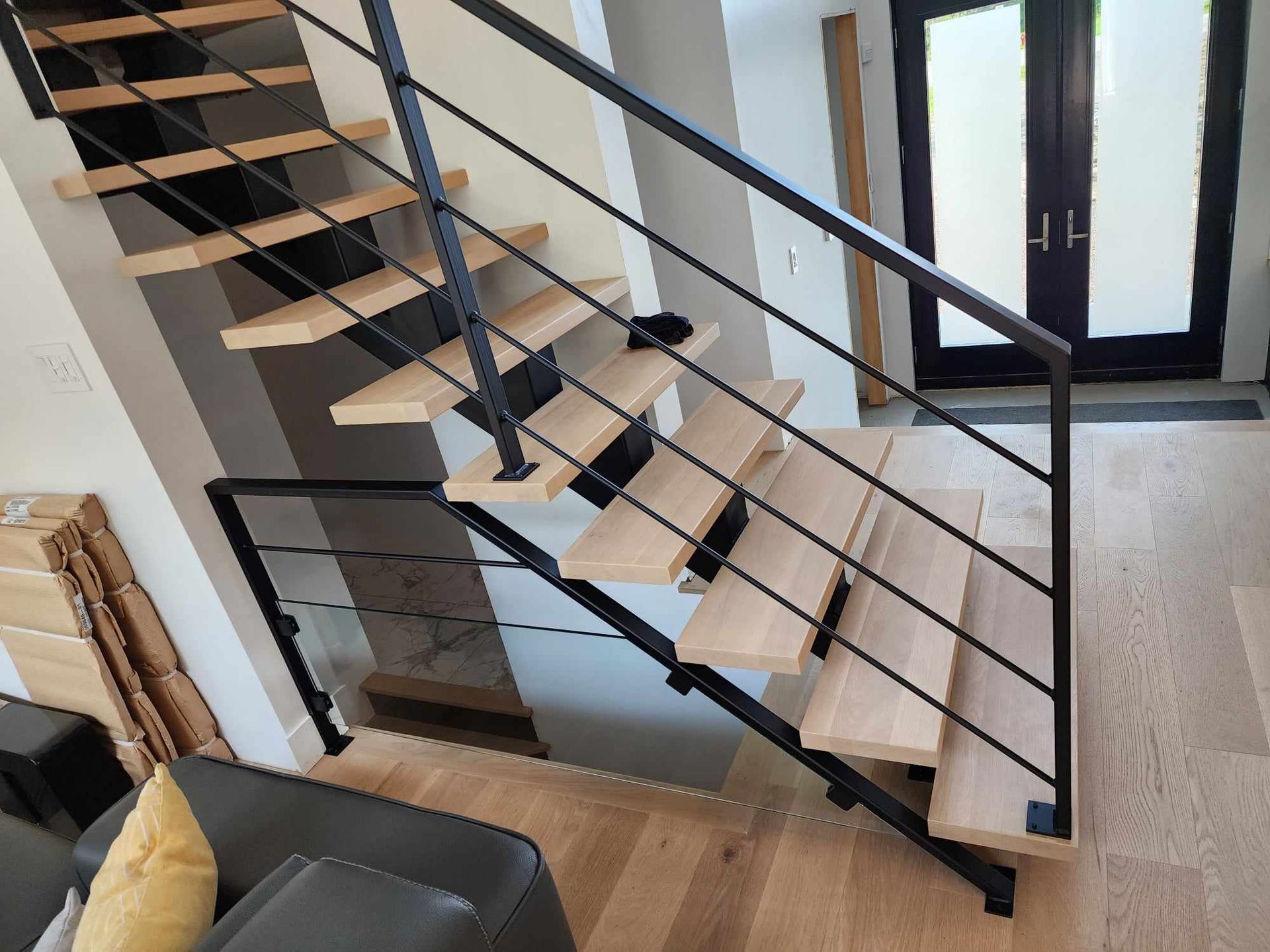 Un escalier en bois avec une rampe noire dans un salon