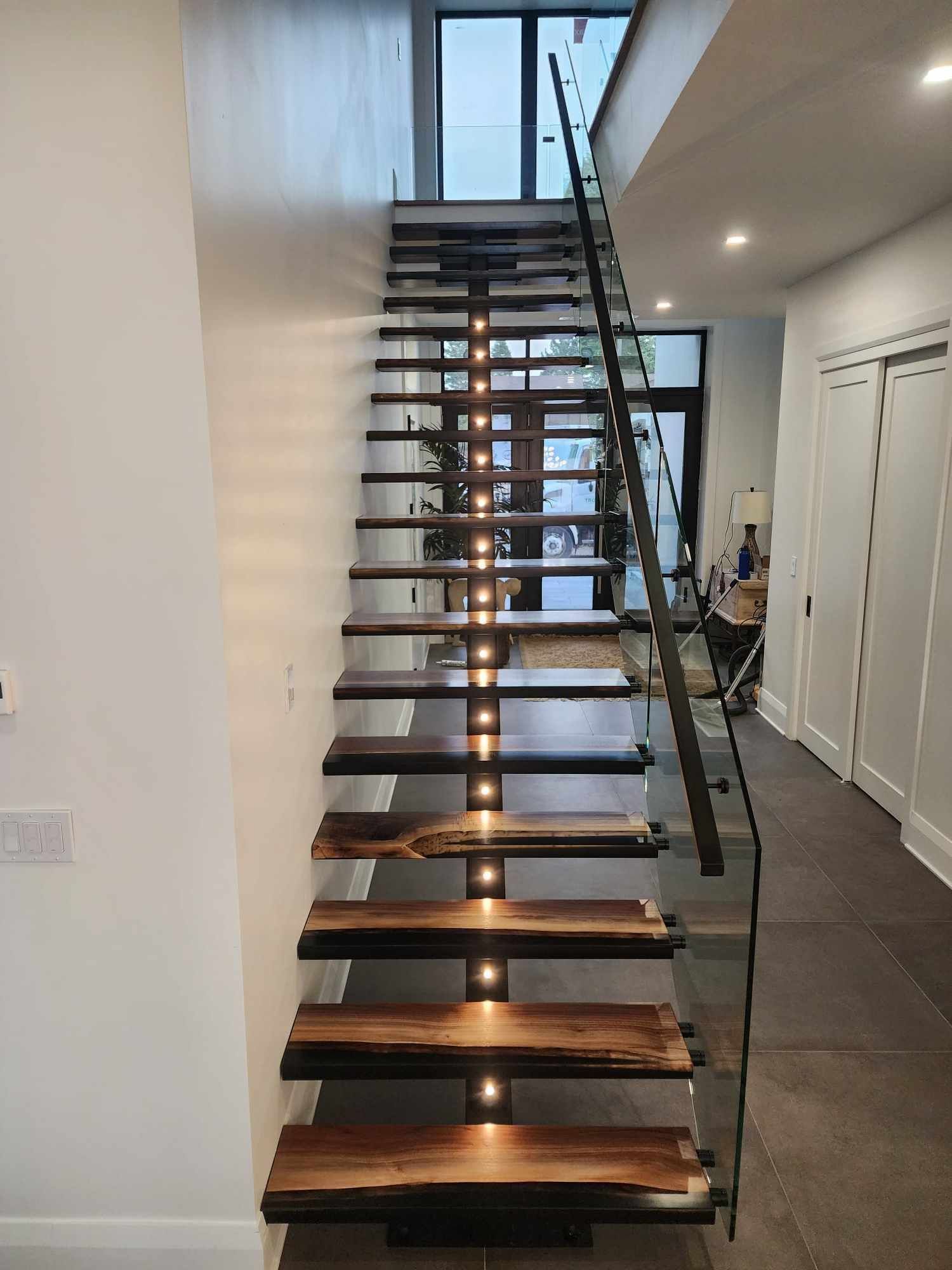 Un escalier en bois avec des lumières sur les marches d'une maison.