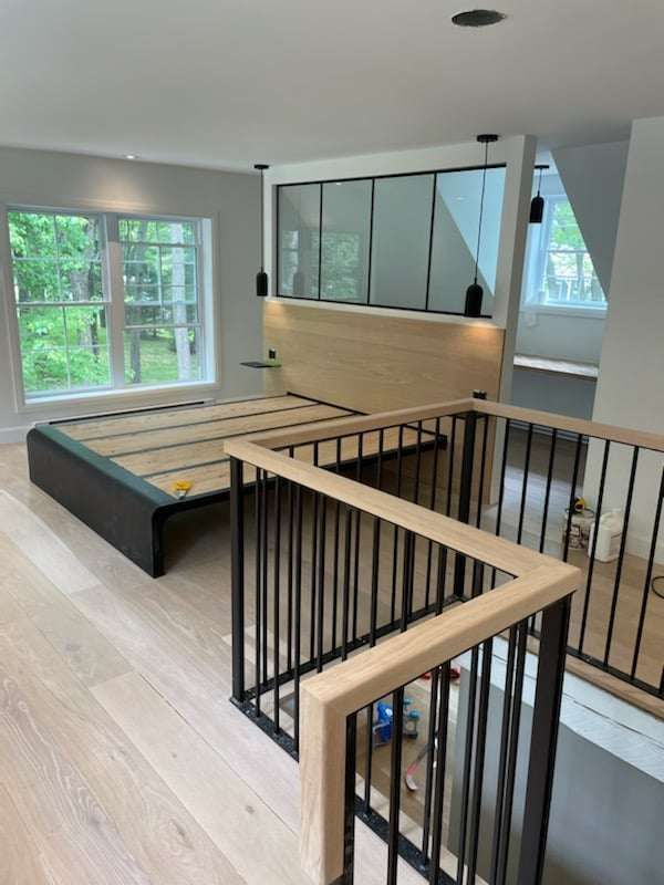 Une chambre avec un lit et un balcon avec une balustrade.
