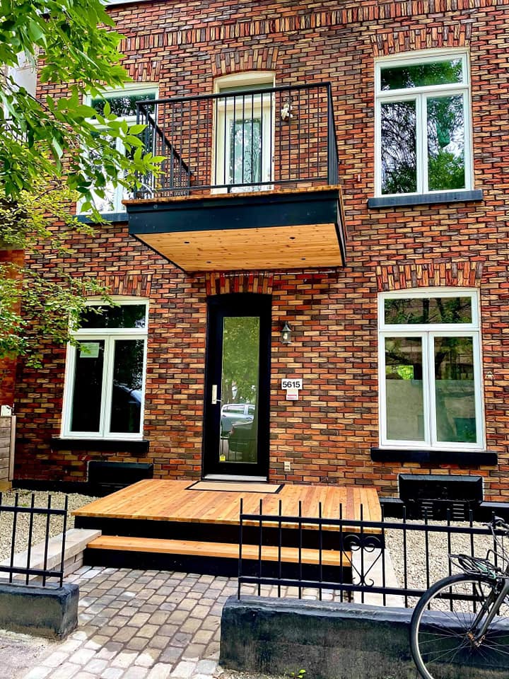 Un bâtiment en briques avec un balcon et un vélo garé devant.