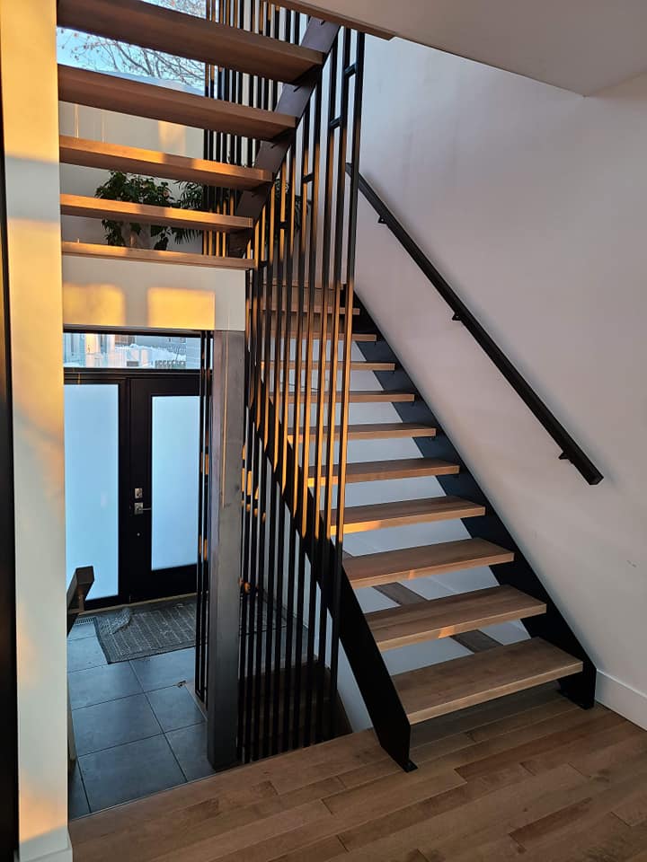Un escalier avec des marches en bois et une rampe en métal