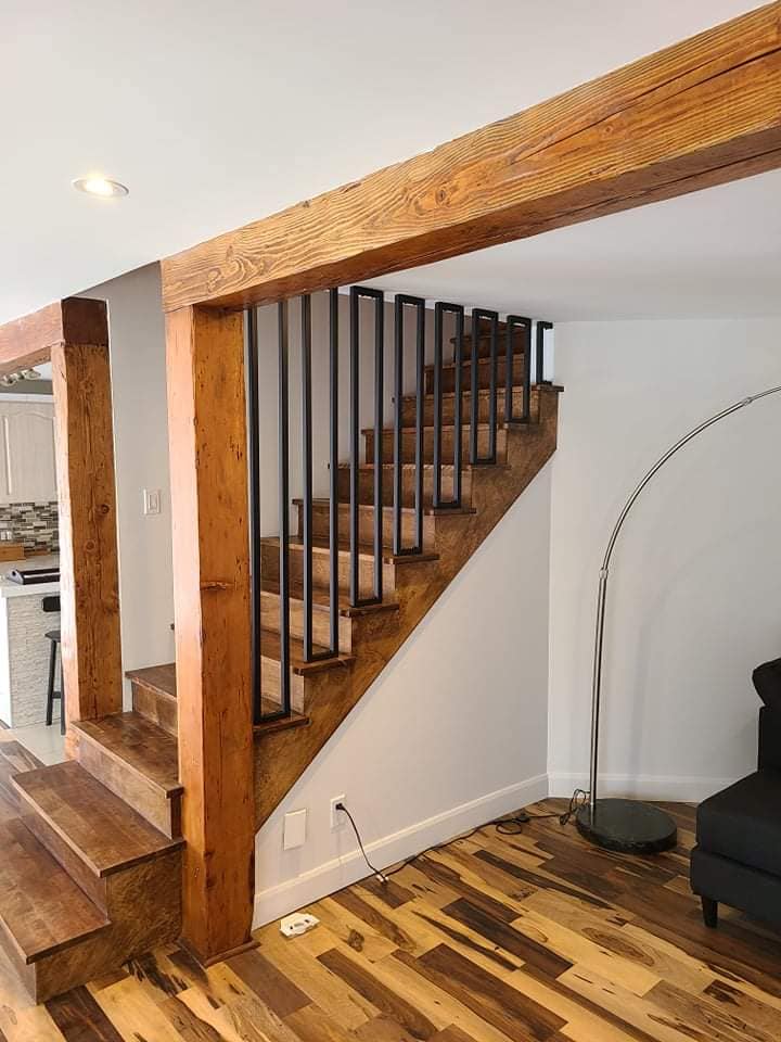 Un escalier en bois avec une rampe en métal dans un salon.