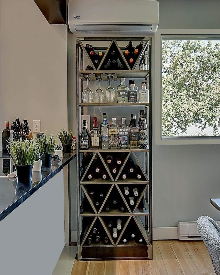 Un casier à vin rempli de bouteilles de vin dans une cuisine.