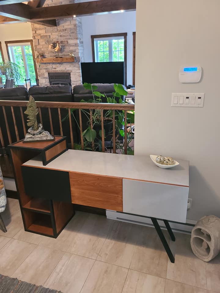 Un salon avec une table et un thermostat au mur.