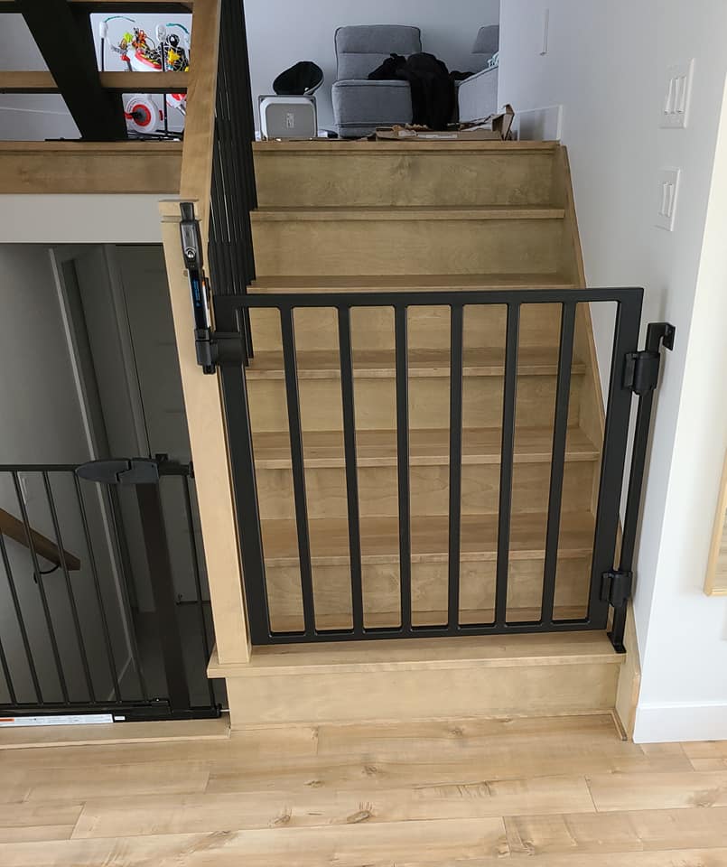 Un escalier en bois avec une rampe en métal et un portail