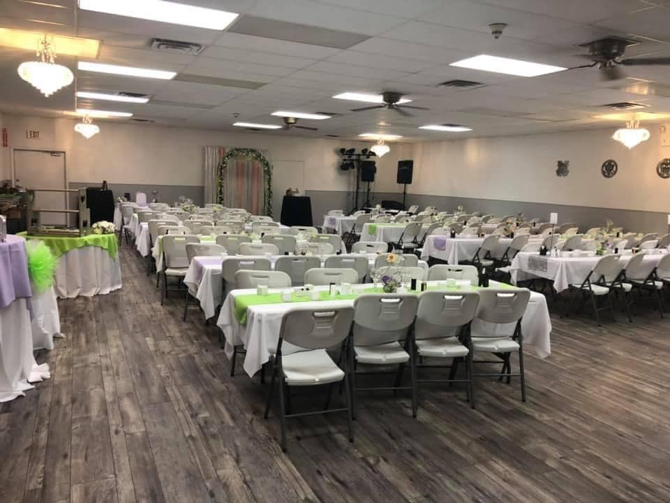 A large room with tables and chairs set up for a party.