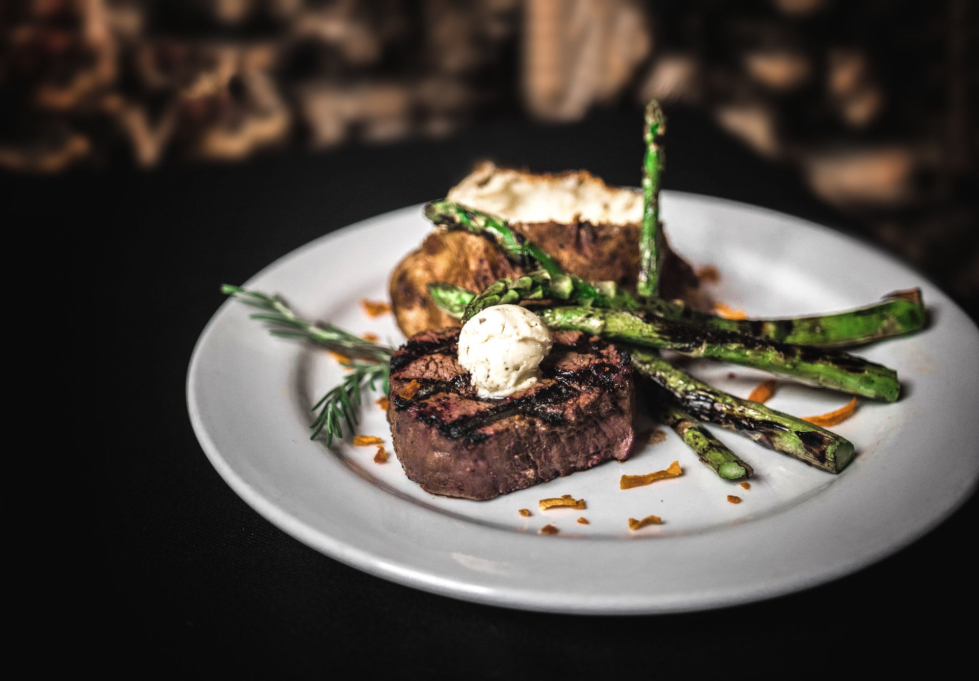 A white plate topped with a steak and asparagus.
