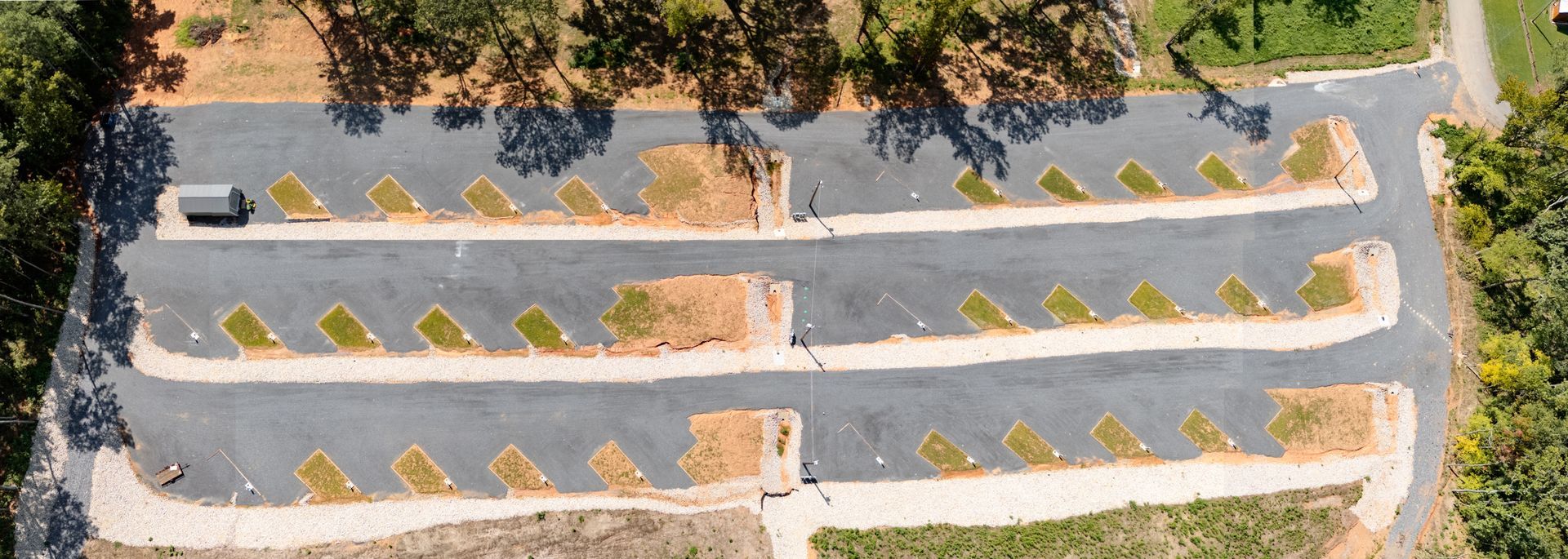 An aerial view of a parking lot with a car parked in the middle.