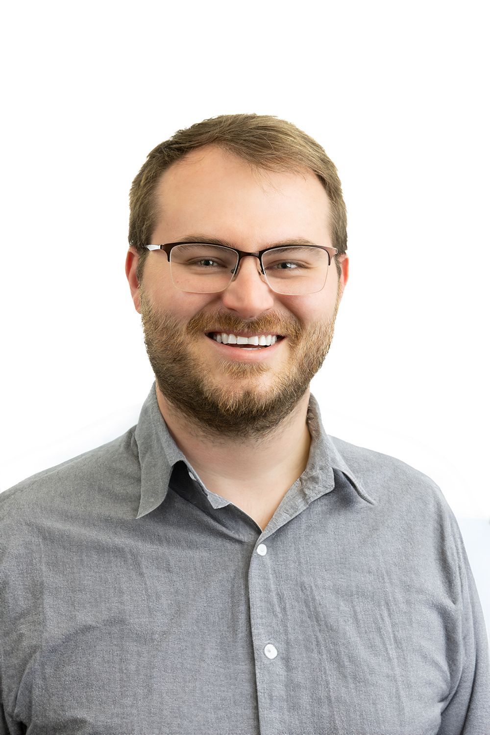 A man with a beard and glasses is smiling for the camera.