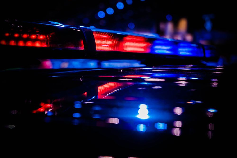 A close up of a police car 's red and blue lights at night.